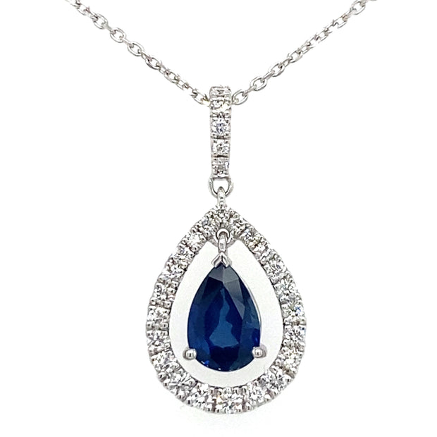 A pear-shaped sapphire pendant with a diamond halo set in 18k white gold, suspended from a fine gold chain.