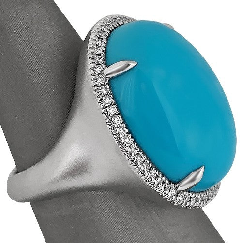 17.56 carat oval cabochon-cut Sleeping Beauty turquoise with 
0.23 carats total weight of round brilliant cut diamond halo.