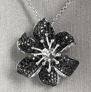 Convertible design allows flower to be worn as a ring or pendant.