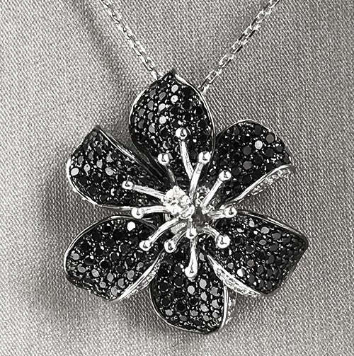 Convertible design allows flower to be worn as a ring or pendant.