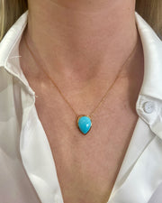Turquoise pendant necklace shown on model.