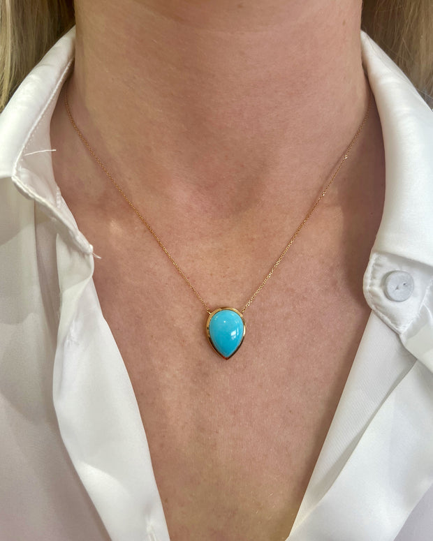 Turquoise pendant necklace shown on model.