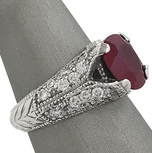 Oval ruby and pavé diamond ring in 14k white gold with milgrain and engraving detail.
