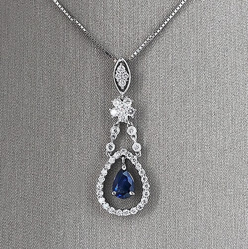 A detailed view of the sapphire and diamond pendant necklace.