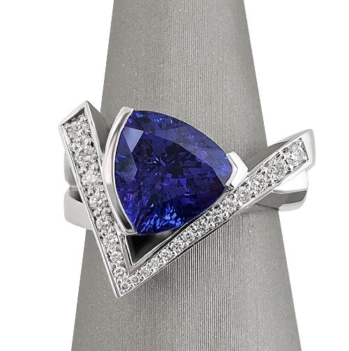 Trillion-cut Tanzanite ring set in 18K white gold with pave-set diamond accents in a V-shaped design