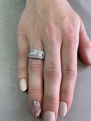 Shown on hand the round brilliant center diamond surrounded by suportive diamonds creates a 
ring that speaks of the past and promises the future.