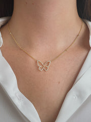 Delicate diamond butterfly necklace on model.