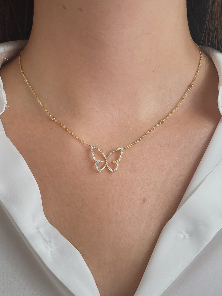 Delicate diamond butterfly necklace on model.